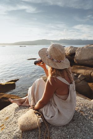Woman relaxing and drinking beer at beach