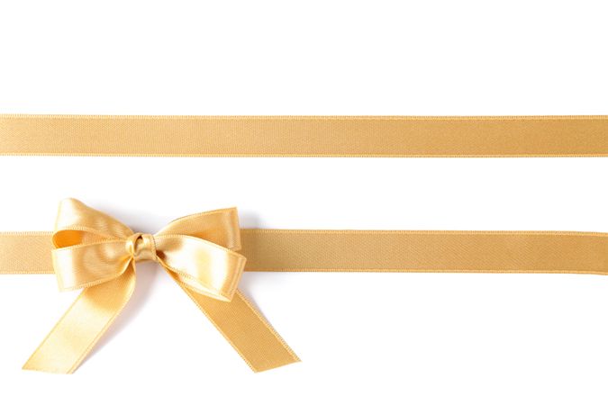 Golden ribbons with bow isolated on blank background. Gift concept