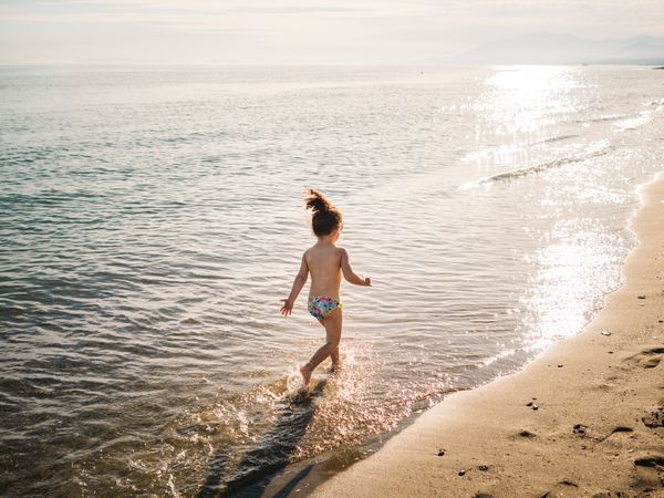 Anonymous girl running on seaside