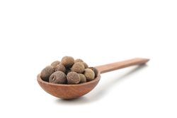 Close up of wooden spoon with peppercorns