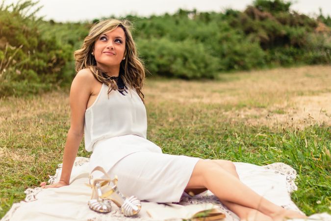 woman looking the sky and sitting outdoors