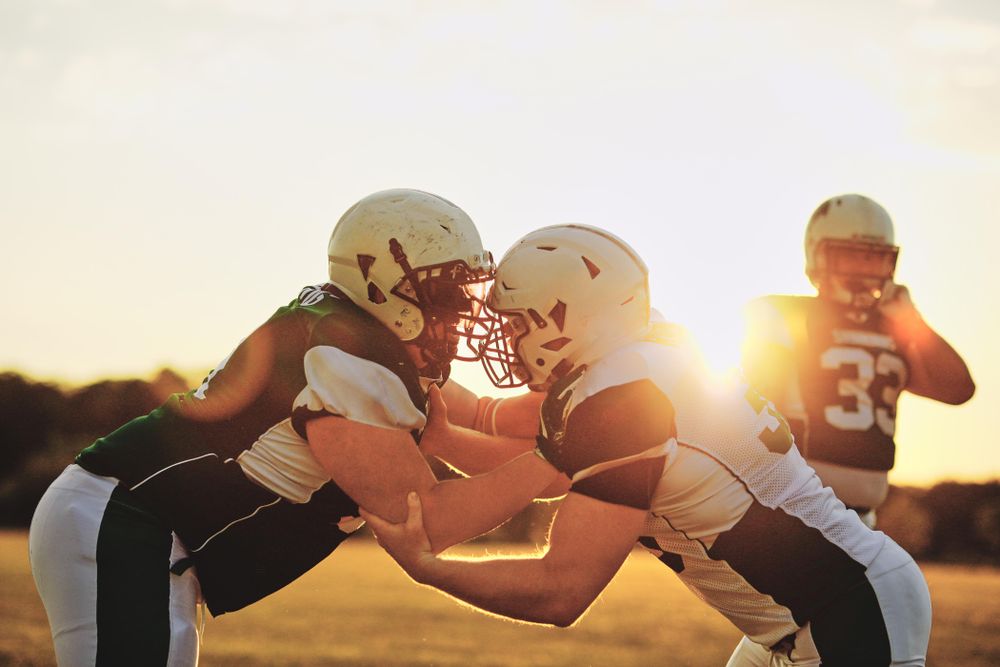 Two men practicing a tackle during football practice
