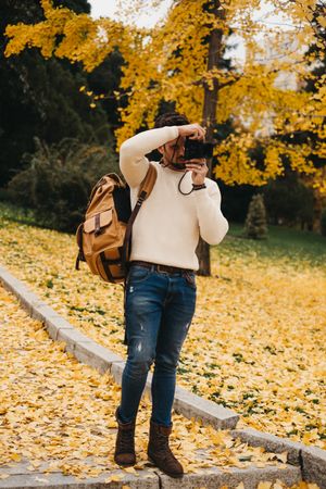 Trendy male with backpack and camera