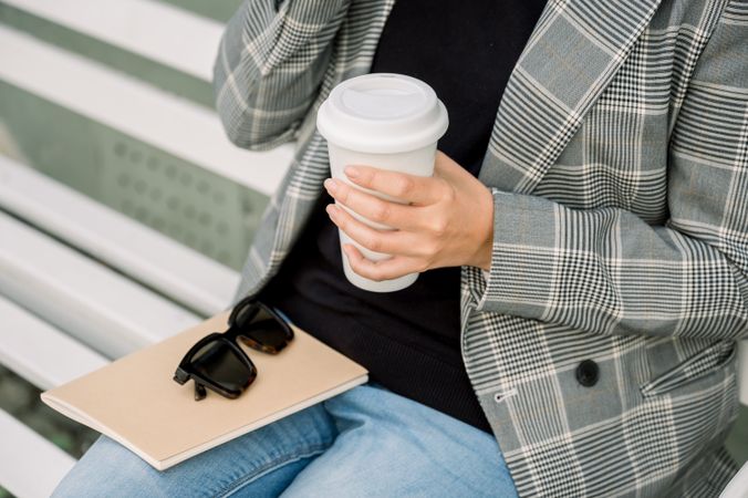 Crop woman with takeaway coffee