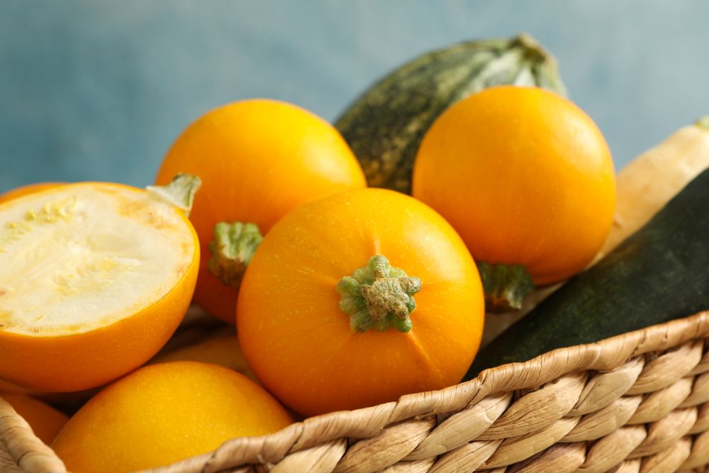 Basket with zucchini on napkin on wooden table