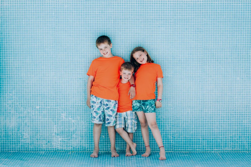 Children standing in empty pool and looking at camera