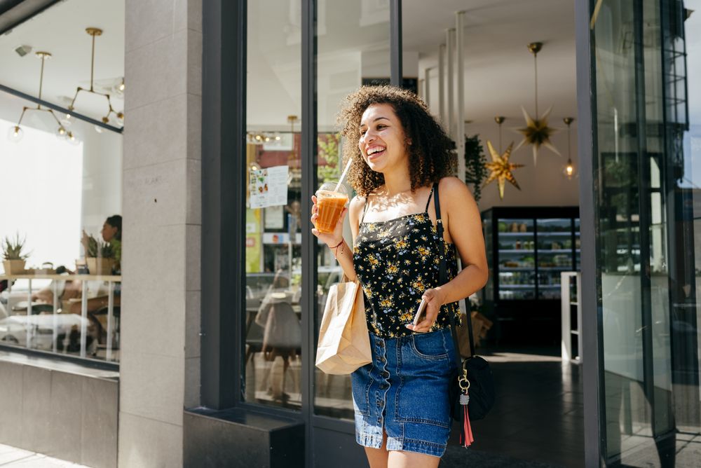 Cheerful hispanic woman leaving restaurant