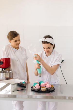 Two female chefs making cupcakes