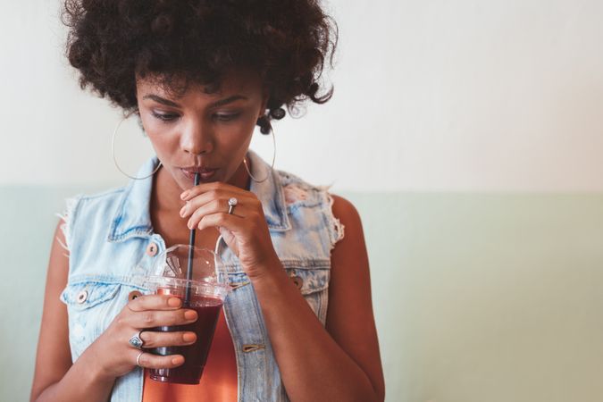 Female model drinking fresh fruit juice with straw
