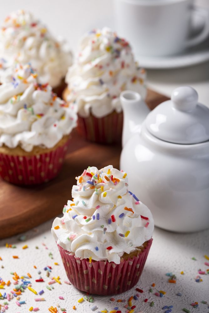 Tasty party cupcakes on the table. Cupcakes with whipped cream.