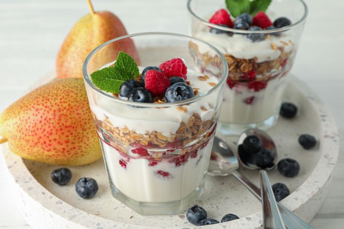 Parfaits and pears on wooden table, space for text