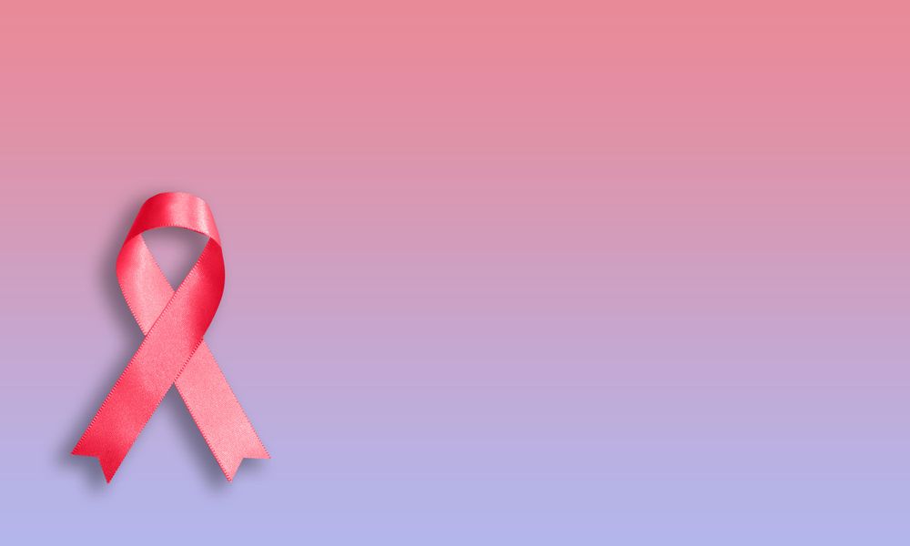 Pink ribbon on pink purple gradient background