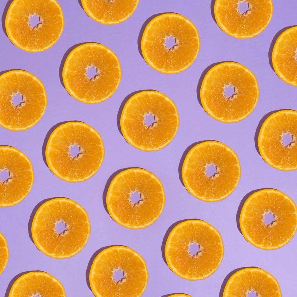 Pattern of orange slices on light purple background