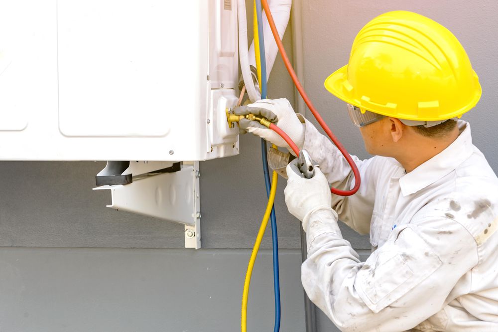 Man in bump cap fixing an electrical machine