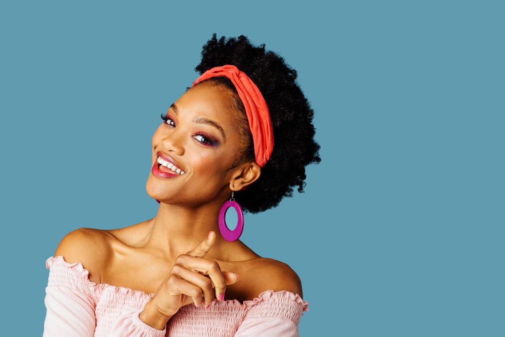 Studio shoot of smiling Black woman pointing jokingly at the camera