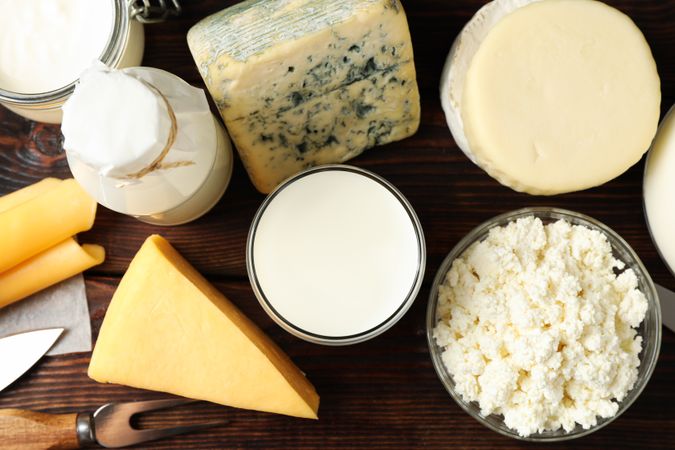 Different dairy products on wooden background, top view