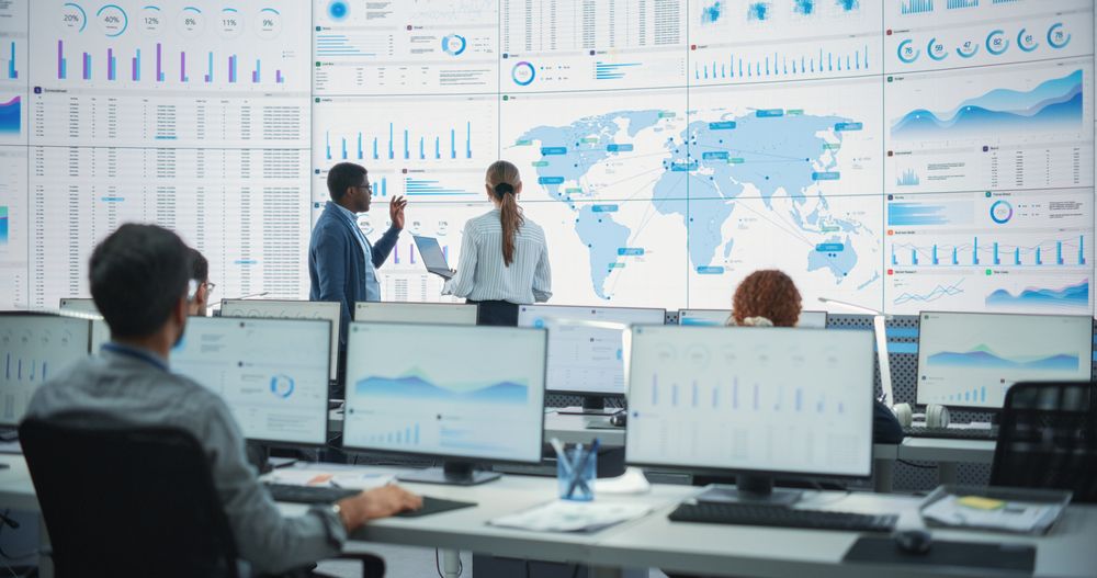 Diverse Employees Working Behind Computers In Logistics Company.