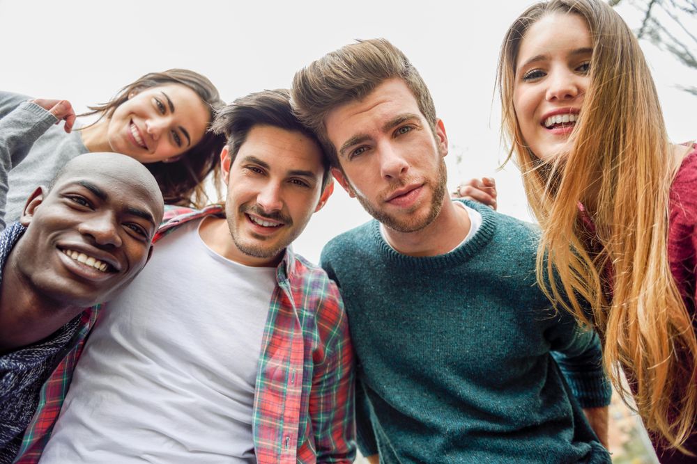 Group of men and women looking down and smiling at camera