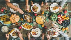 Group of people serving turkey over festive dishes