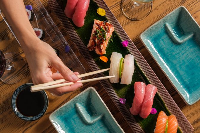 Person with chopsticks eating traditional Japanese sushi