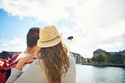 Rear view of couple taking a picture with a selfie stick
