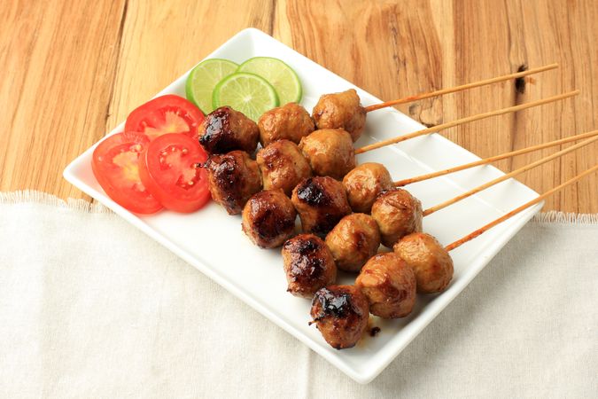 Baso bakar, grilled meatballs coated with soy sauce, Indonesian street food