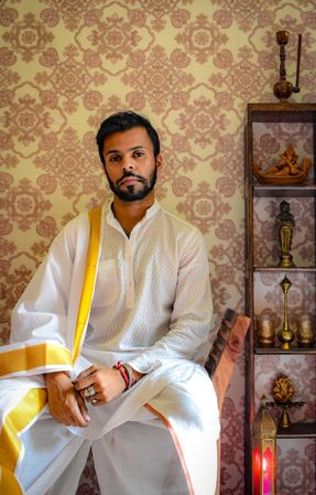 Man in light traditional outfit sitting on chair