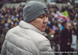 London, England, United Kingdom - March 5 2022: Asian man in grey hat and coat in crowd 0LOVrb