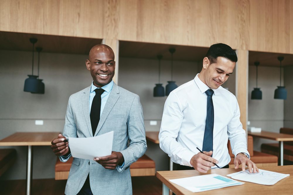 Two business men going over notes in an open office