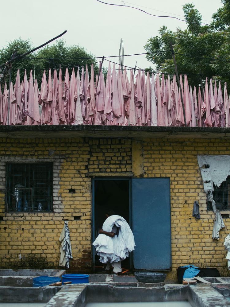 Person holding a bunch of towels standing beside a door