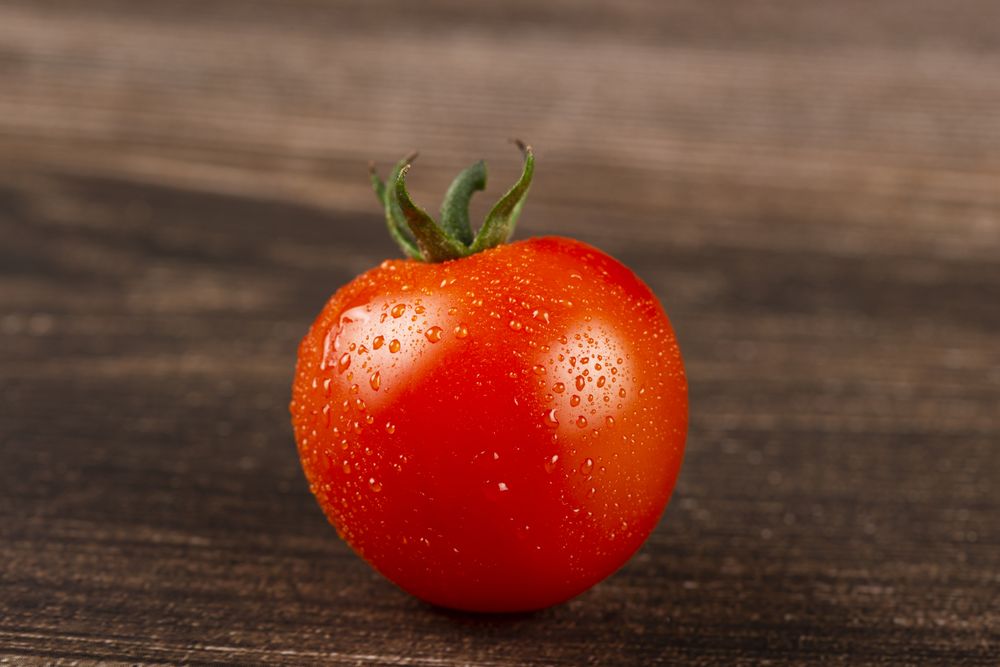 Ripe fresh tomato on the wooden table.