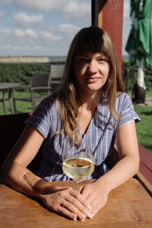 Young woman drinking wine in arbor