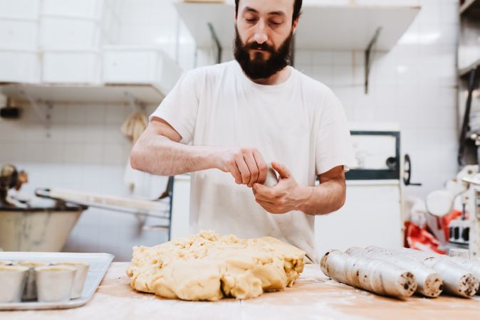 Unrecognizable cook putting pastry dough in cup
