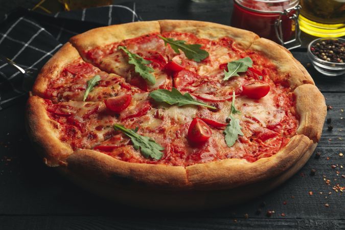 Tasty pizza and ingredients on wooden background