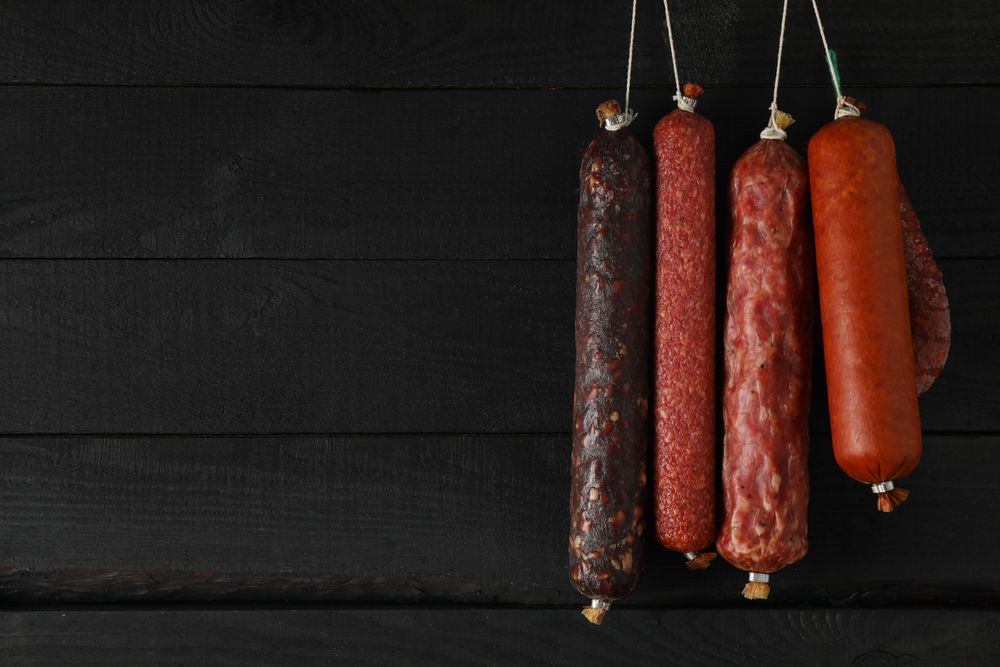 Variety of sausages hanging in a row, copy space