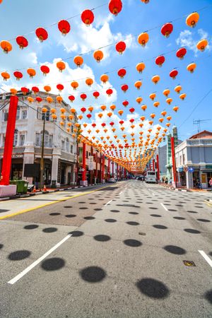 Street decorated with red lanterns under blue sky