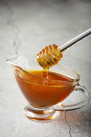 Honey in glass bowl on the table.