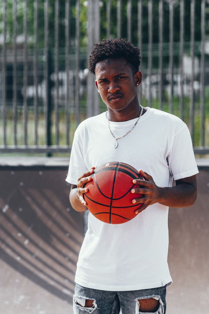 Black sportsmen with ball and looking at camera