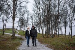 Couple walking on park path near sea