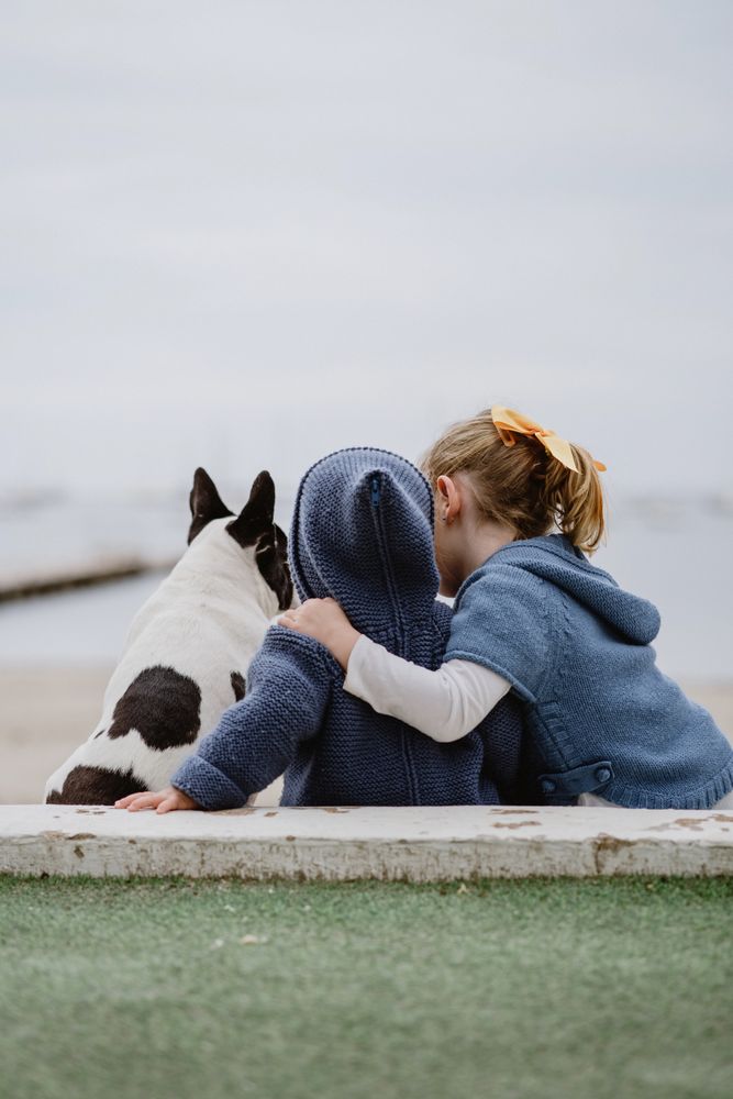 Kids hugging dog on beach