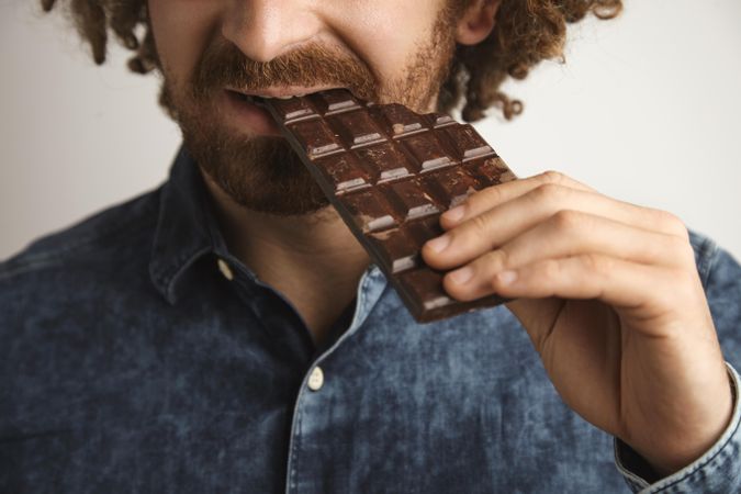 Close up of man biting into chocolate bar