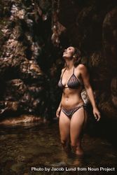Adventurous woman standing in a plunge pool in a bikini bDnPE5