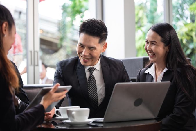 Two smiling Asian colleagues happy with meeting outcome