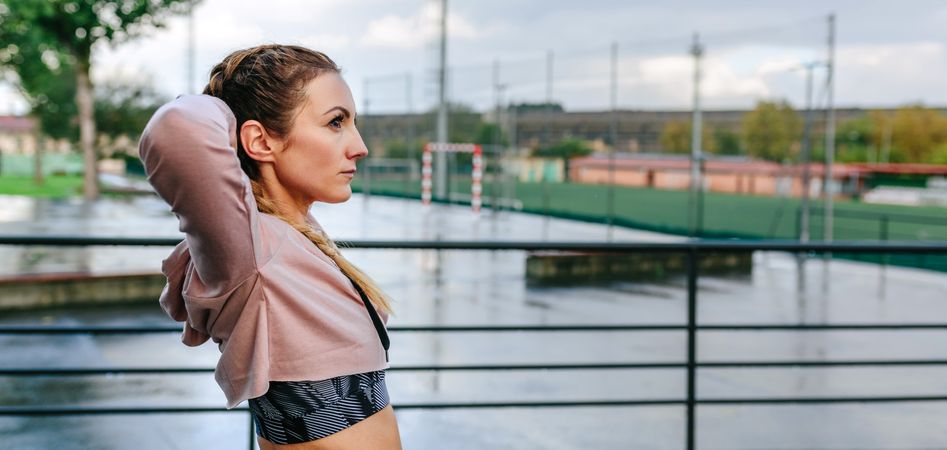 Sportswoman stretching neck and shoulders outdoors