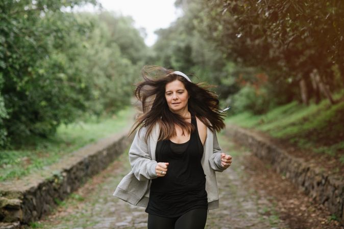 Positive woman running in park