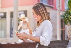 Positive female browsing phone on street