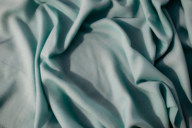 Nude green fabric wavy crumpled background texture with copy space.