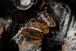 Pieces of Stollen near sieve and autumn leaves
