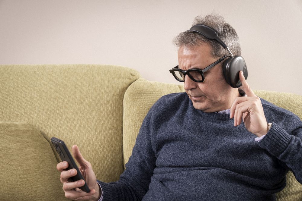 Man practicing mindfulness meditation with headphones at home.
