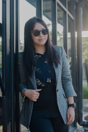 Confident young entrepreneur leaning against modern architecture